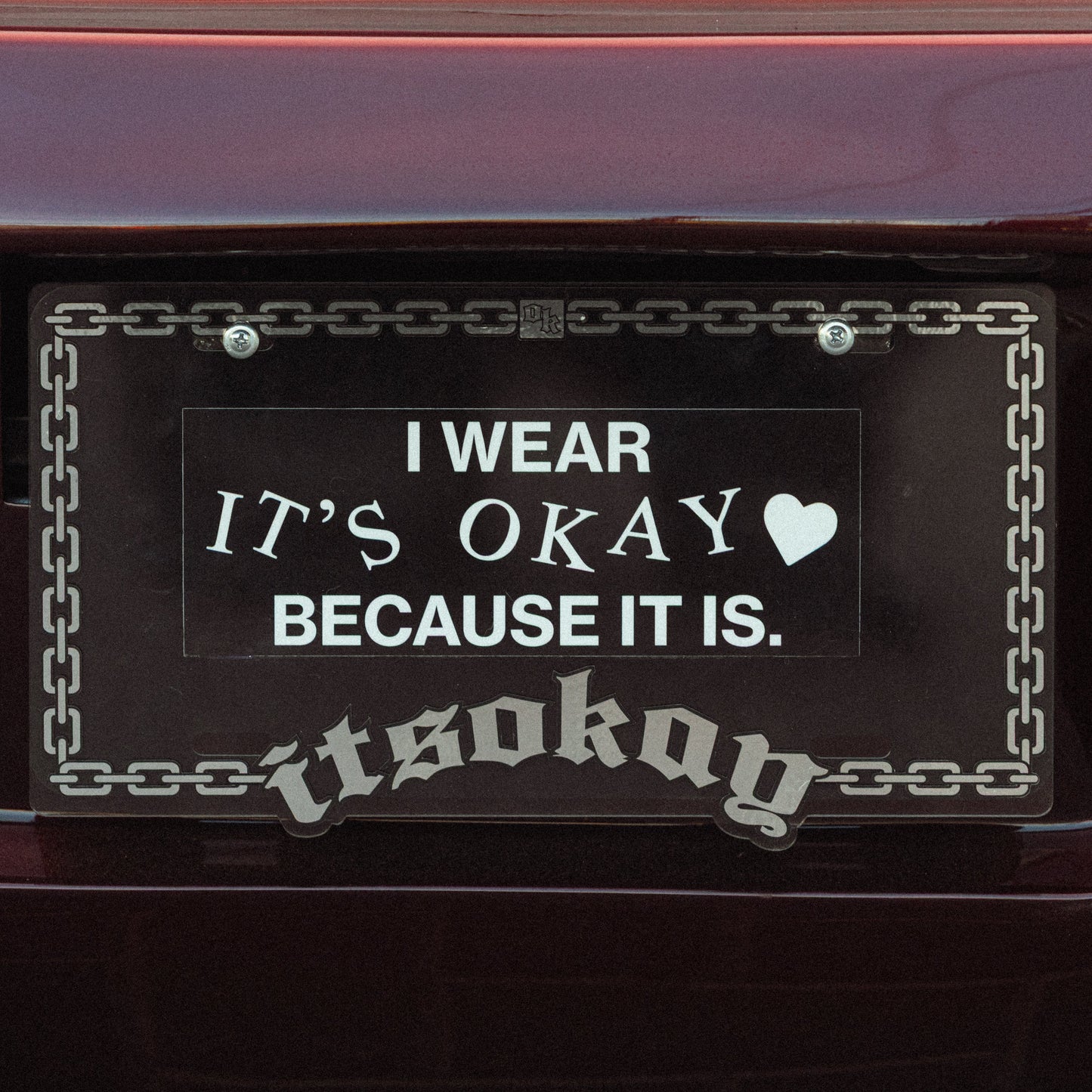 License plate with text 'I WEAR IT'S OKAY BECAUSE IT IS.' on a vehicle.