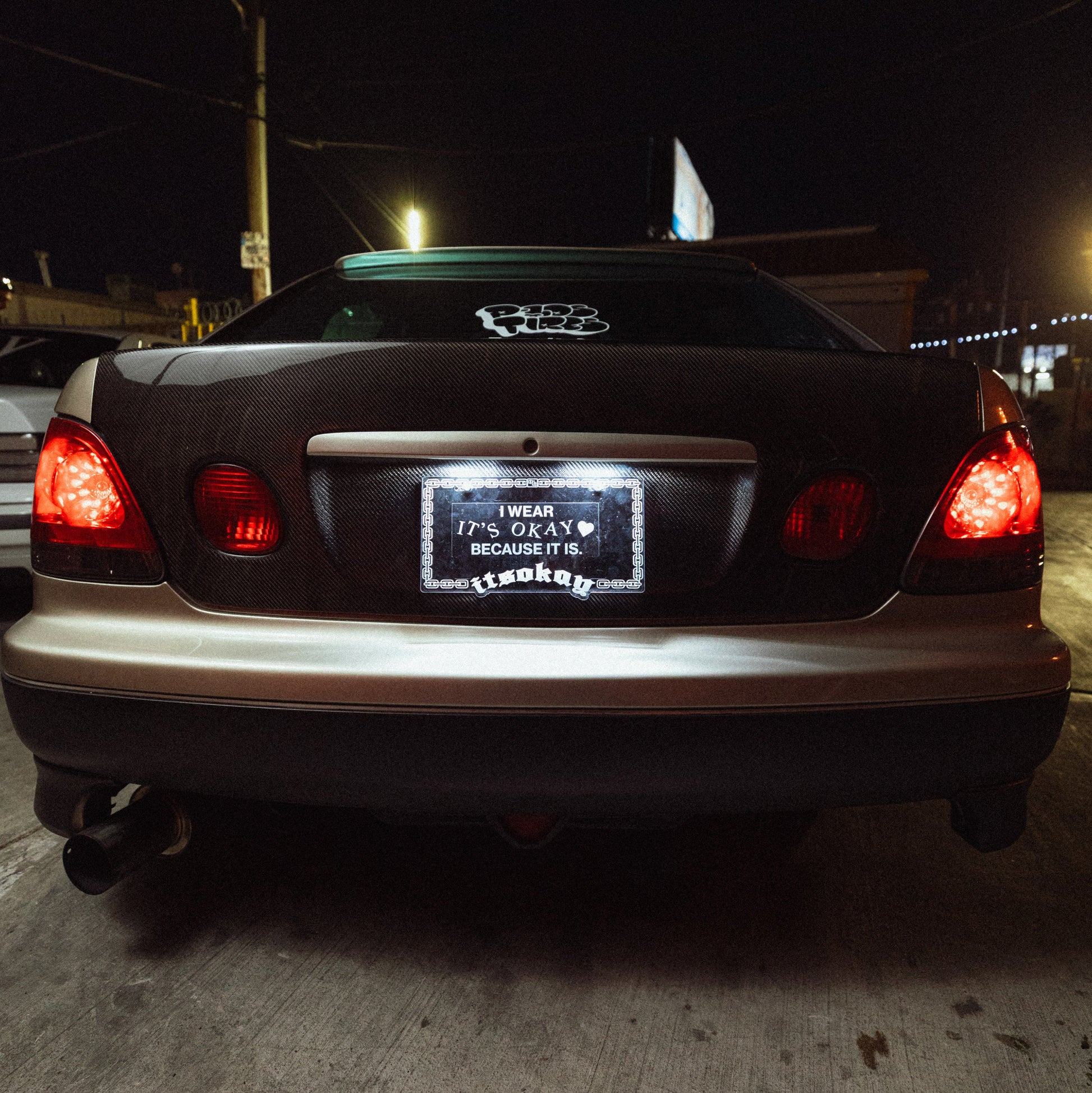Car's rear view at night with visible license plate and Audi logo.